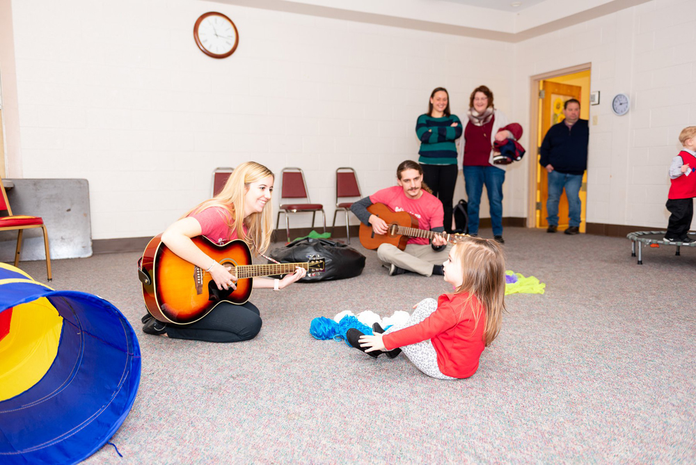 music therapy teachers playing guitar with children